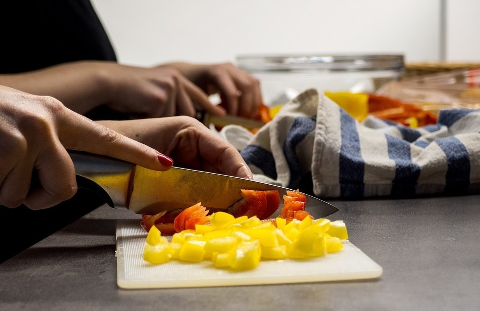 woman’s hands cutting vegetables with a chef knife
