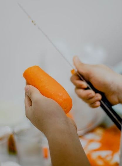 person peeling carrot